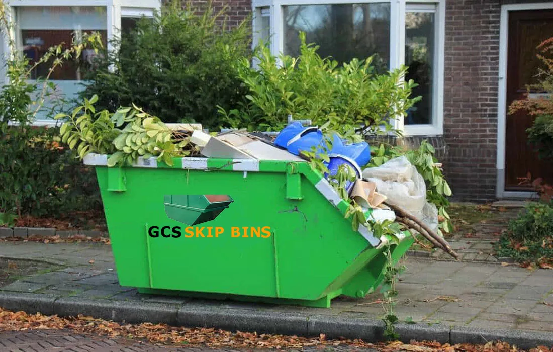 Green waste skip bin filled with garden branches and clippings