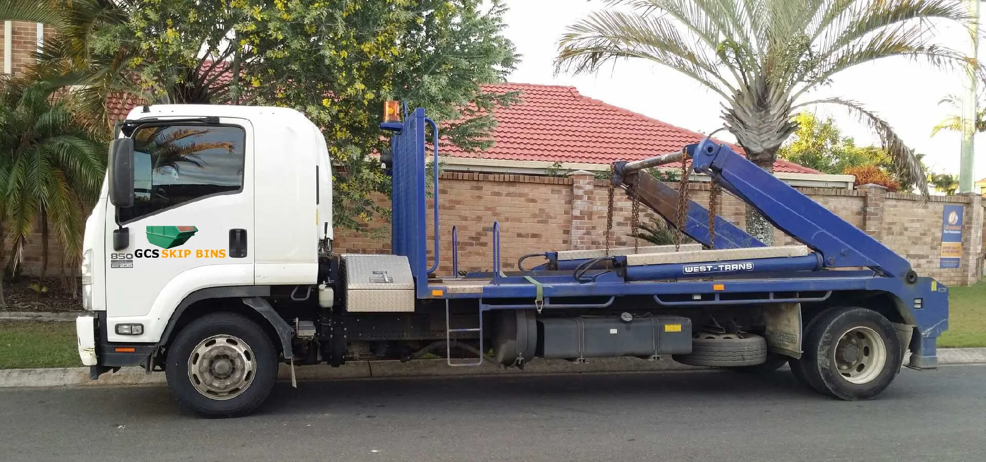 GCS Skip Bins truck delivering a skip bin on a residential street